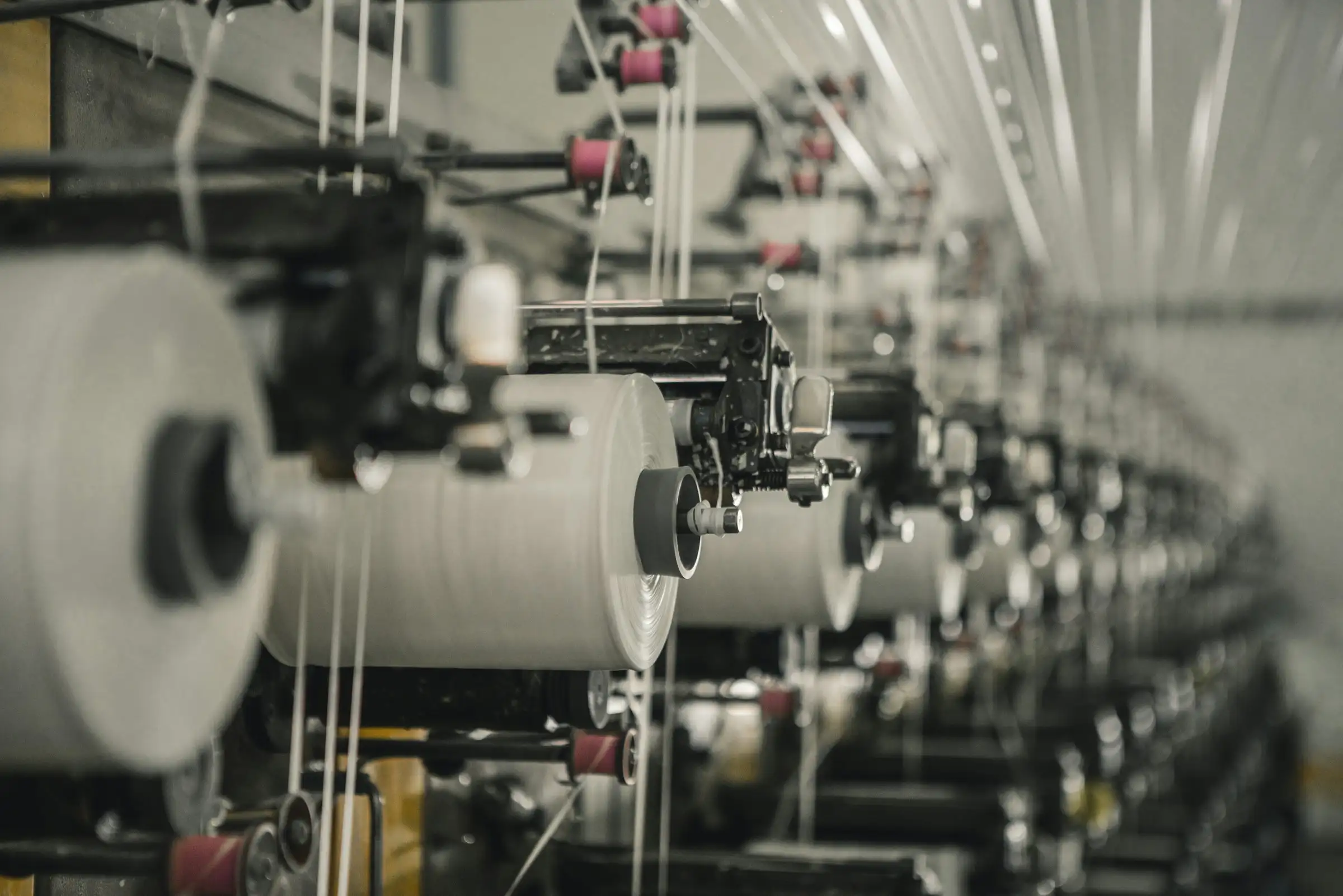 Reihe industrieller Spinnmaschinen in einer Fabrikhalle