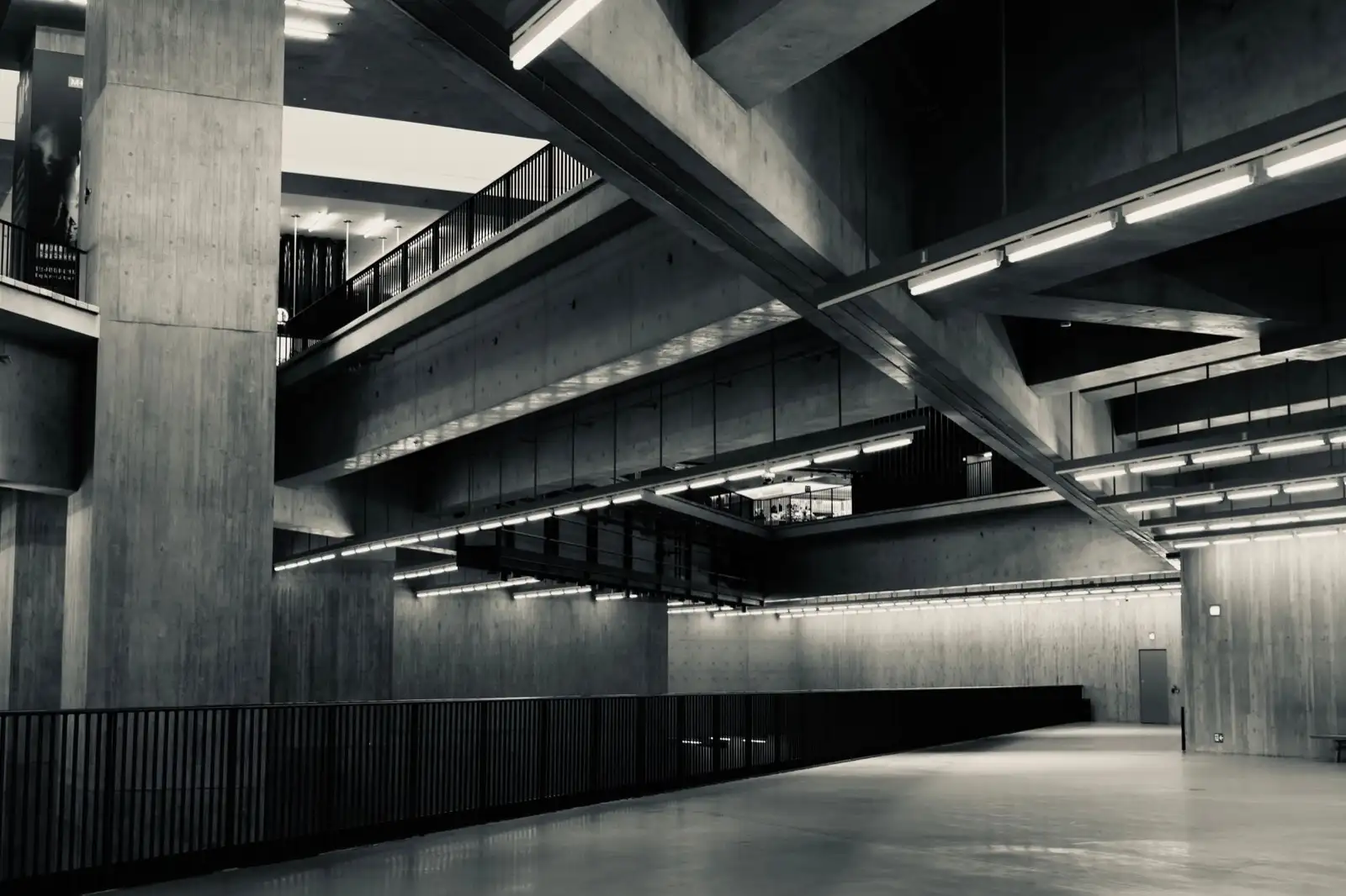 Empty concrete hall of a public building with lit galleries