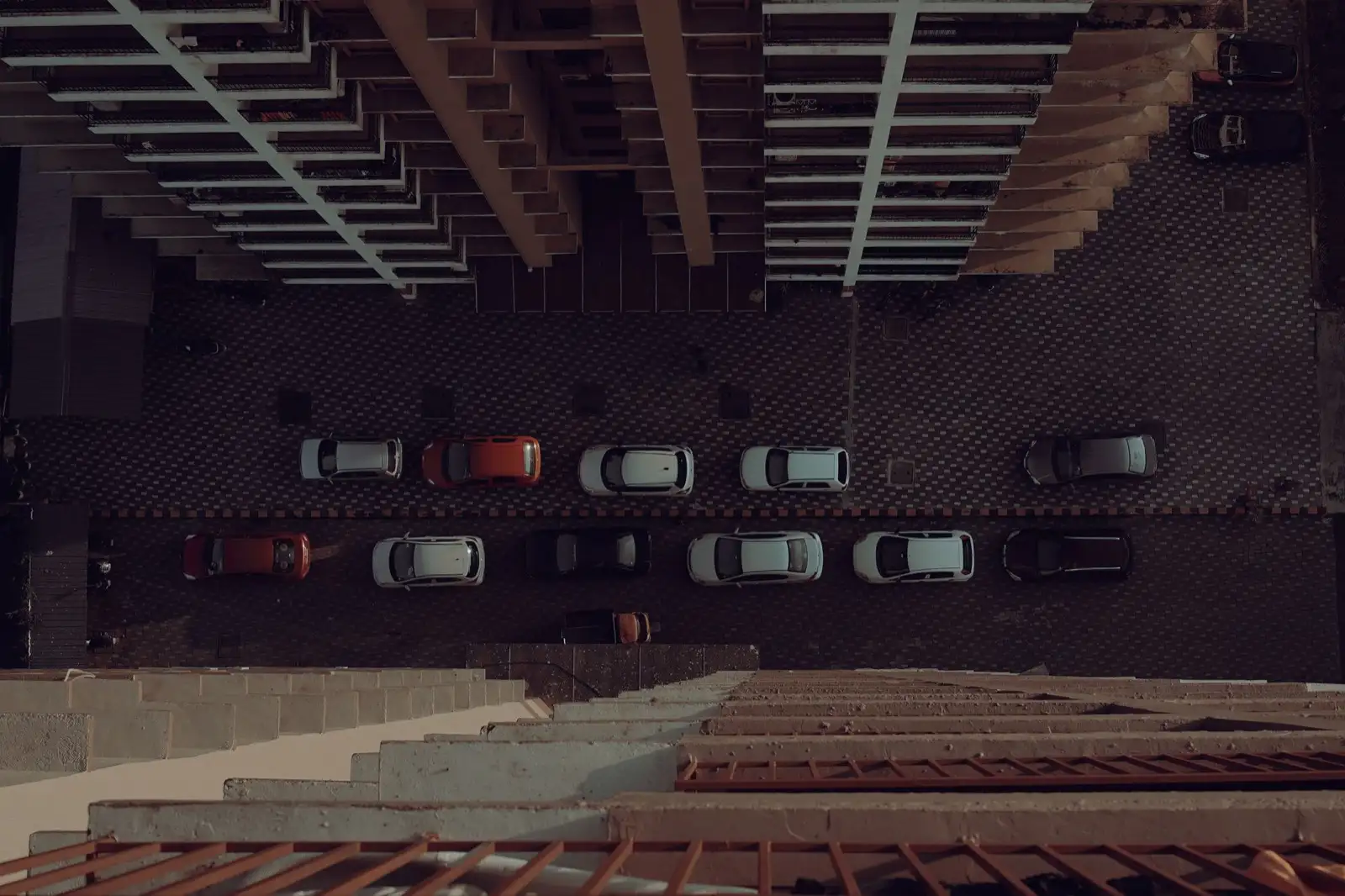Blick von oben auf parkierte Autos in einer Strasse zwischen Wohnblöcken