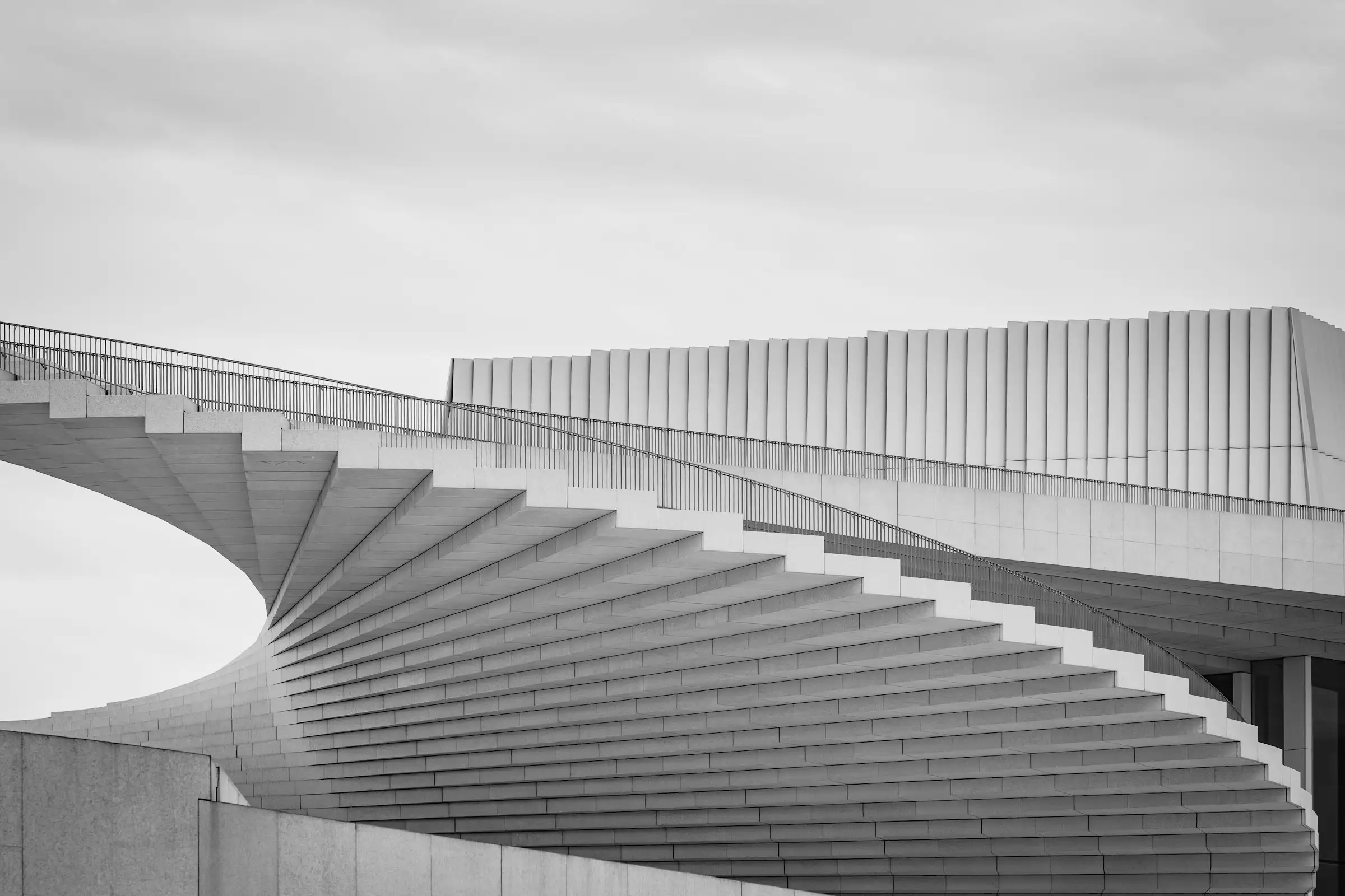 Wendeltreppe aus Beton vor grauem Himmel