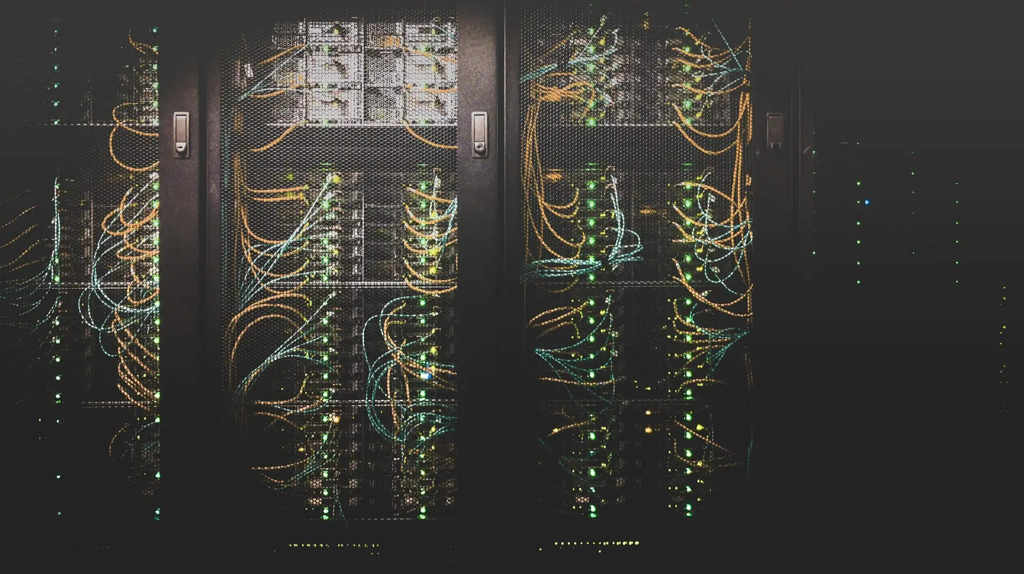 Serverschränke mit sauber verlegten Netzwerkkabeln in einem dunklen Raum
